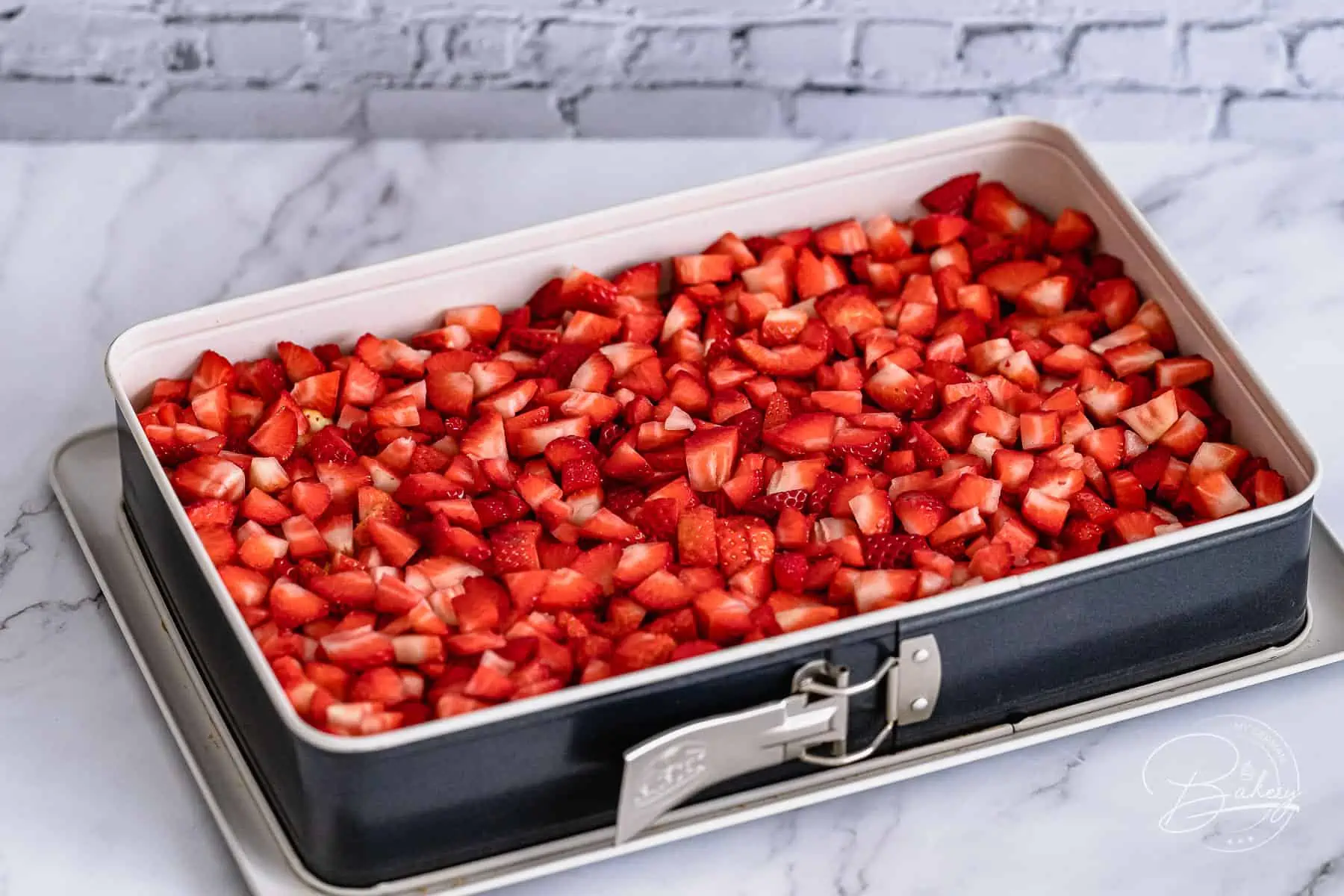Die einfachste Methode für ein perfektes Ergebnis. Klein geschnittene Erdbeeren in der Form verteilen und anschließend die Sahne hinzugeben.