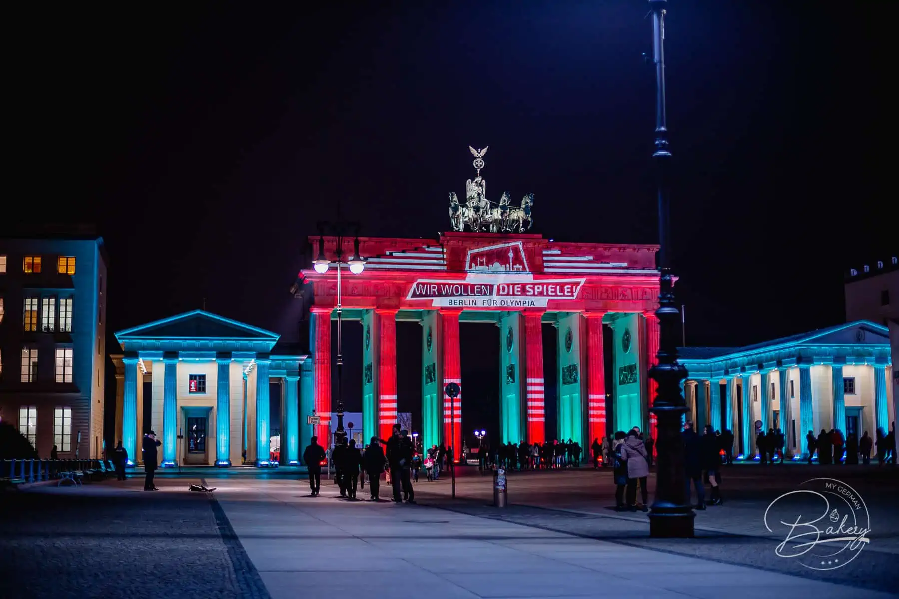 Goldene Currywurst in Berlin essen mit Blick auf das Brandenburger Tor